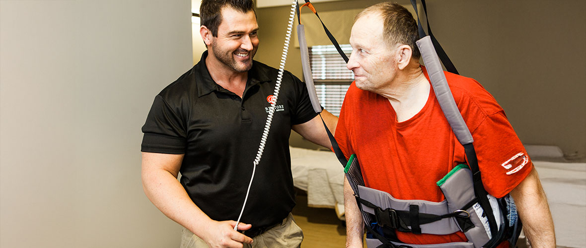 Three female nurses and a male nurse wearing a stethoscope stand outside an emergency room entrance.