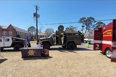 A Jacksonville Police Department Humvee, a police cruiser, and a Jacksonville Fire Department rescue unit on display at Public Safety Week on the Jsu campus