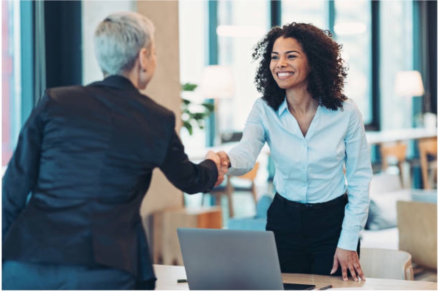 A partner and an instructor shake hands over the table.