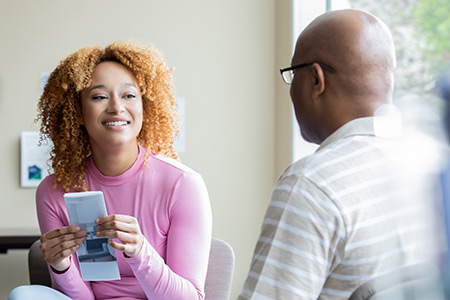 A social worker reviews important information with a client in a home setting