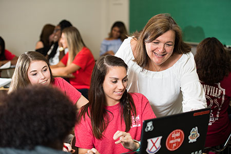 A faculty member helps a student in the classroom