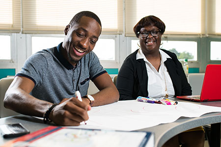 A male social work student studies with a classmate