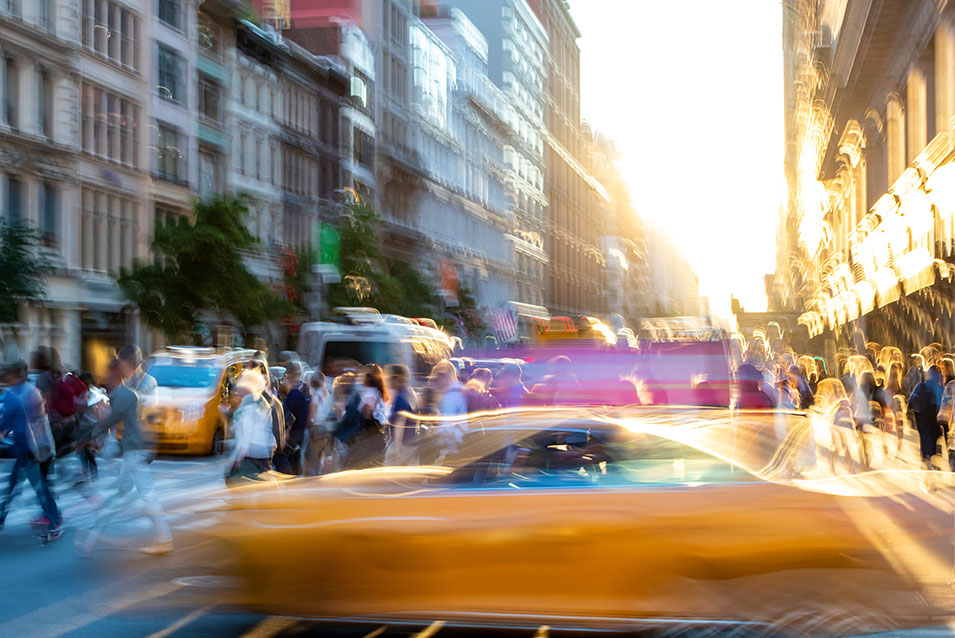 A busy NY street with crowds and taxis