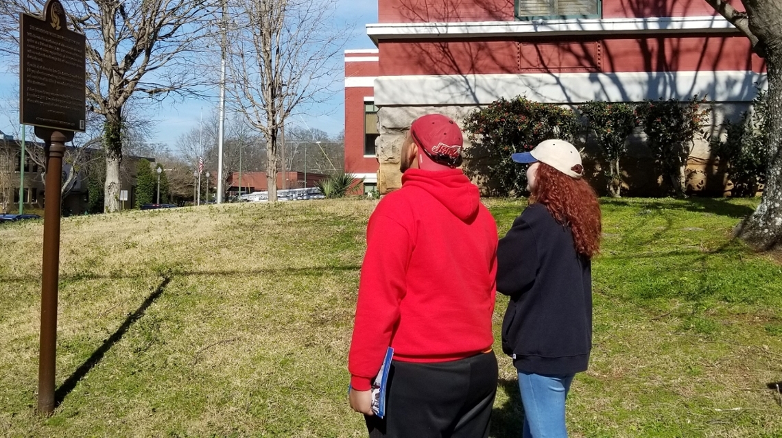 Students reading a Civil Rights Trail sign outside the Calhoun County Courthouse in Anniston, Alabama.