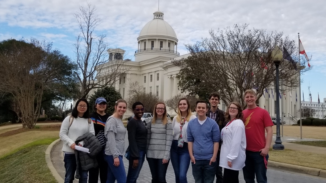 Students standing in Montgomery with the Alabama Capitol in the background