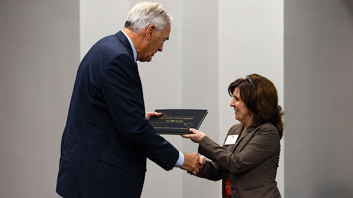 Provost and Senior Vice President of Academic Affairs Dr. Christie Shelton presents The Honorable Luther Strange with a personalized copy of Houston Cole Library at 50 Years following the Free Speech Forum. All panelists and moderators received a copy of the book that is a historical and architectural exploration of Jacksonville State University's Libraries. 