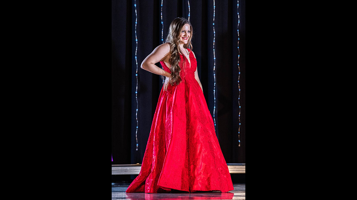 A contestant in the evening wear portion of the competition wearing a red dress