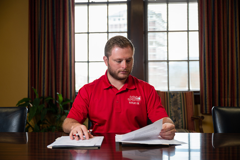 Cody Beck at table, reviewing papers