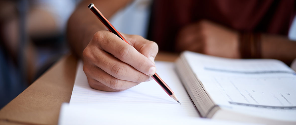 Student holding pencil taking a test